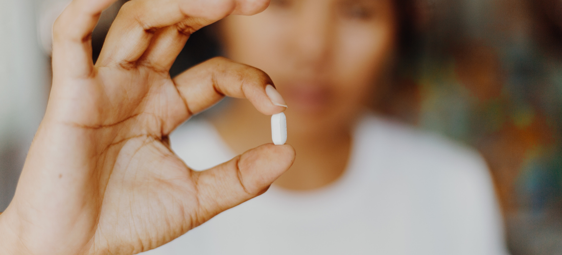 Hand holding a compounded progesterone capsule